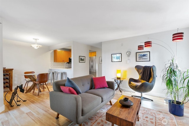 living room with light wood-type flooring and baseboards