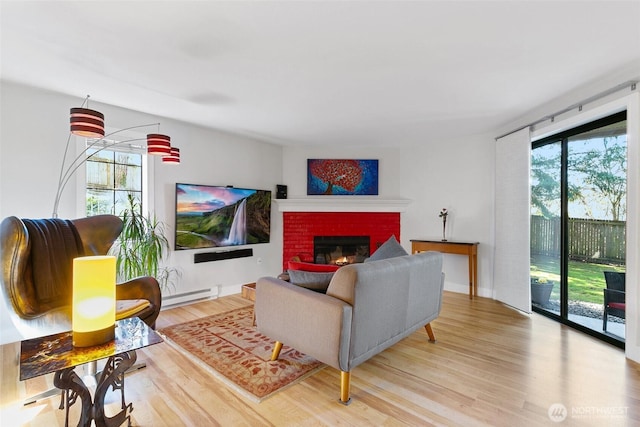 living room featuring a baseboard radiator, a fireplace, and wood finished floors