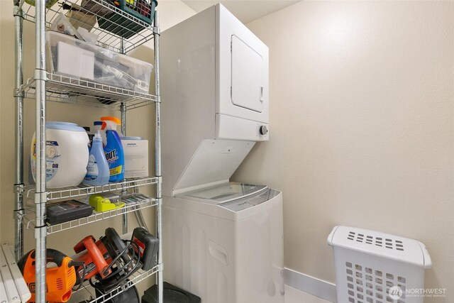 laundry room featuring stacked washer and dryer, laundry area, and baseboards