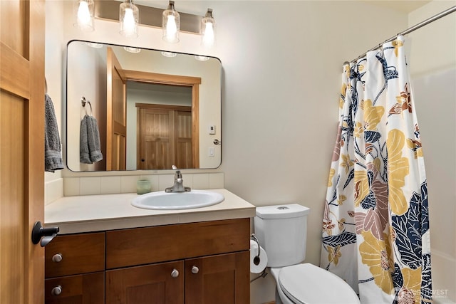 bathroom with curtained shower, vanity, and toilet