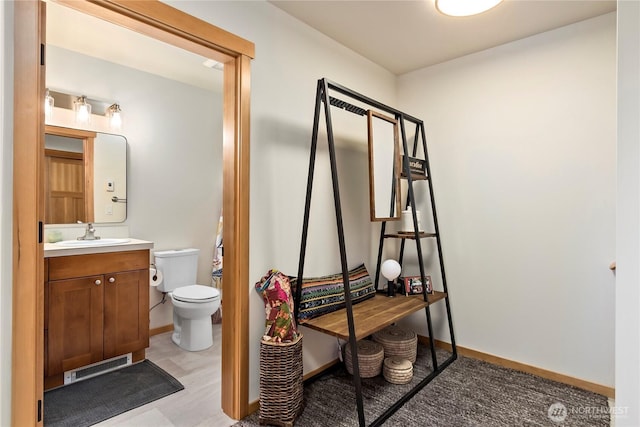 half bathroom featuring toilet, baseboards, visible vents, and vanity