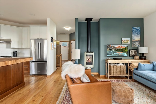 interior space featuring light wood finished floors and a wood stove