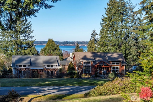 view of front facade with a front yard and a water view