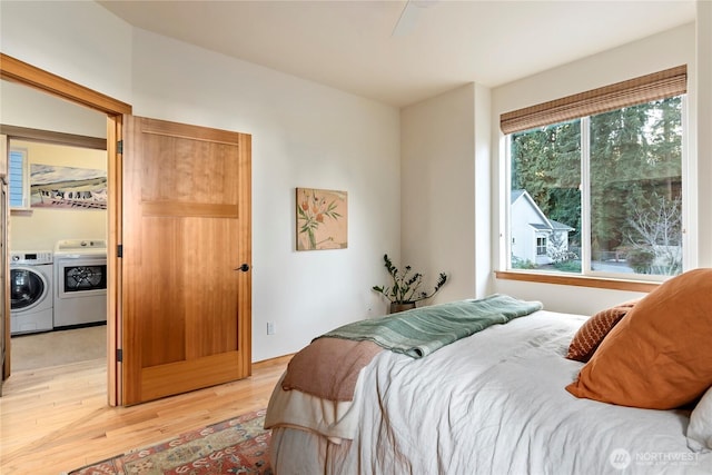 bedroom featuring separate washer and dryer and light wood-style flooring