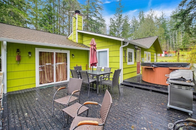 wooden deck with a hot tub and outdoor dining area