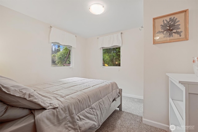 bedroom featuring light carpet and baseboards