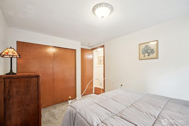 bedroom featuring a closet and light colored carpet