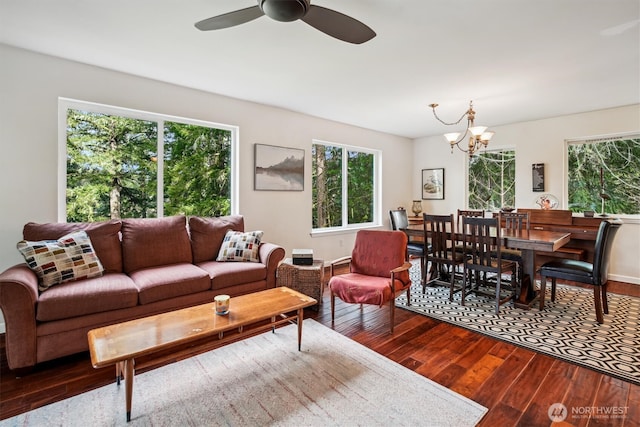 living room with ceiling fan with notable chandelier and wood finished floors