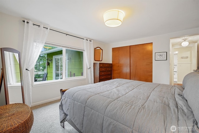 bedroom with light carpet, baseboards, and a closet