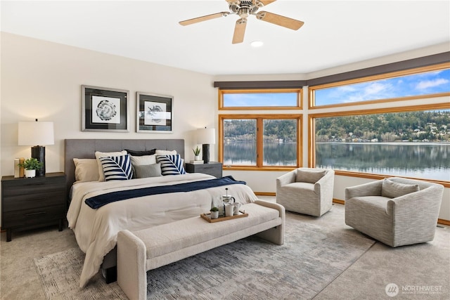 bedroom with a water view, ceiling fan, multiple windows, and carpet floors