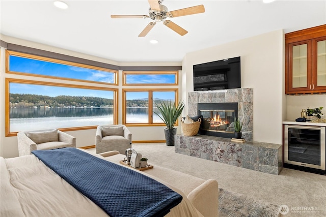 carpeted bedroom featuring wine cooler, a fireplace, a ceiling fan, and recessed lighting