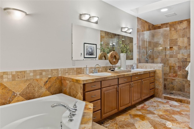 bathroom featuring a bath, double vanity, a tile shower, and a sink