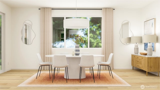 dining space featuring baseboards, plenty of natural light, and light wood finished floors