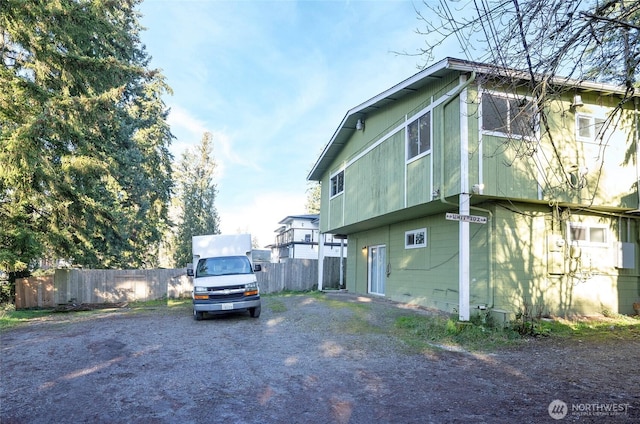 view of home's exterior with fence and driveway