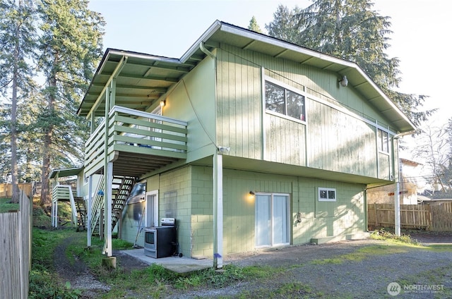 back of property featuring stairway, concrete block siding, fence, and a wooden deck