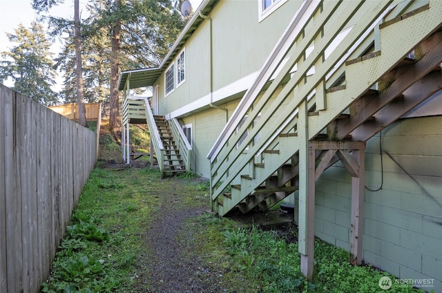 view of property exterior with stairs and fence