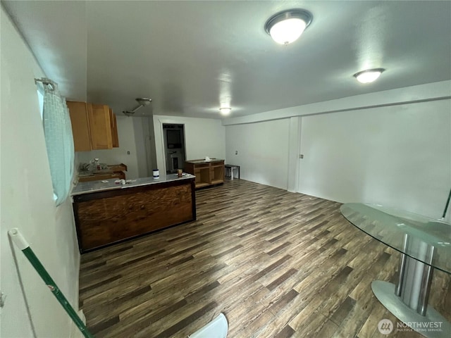 kitchen featuring light countertops, dark wood-type flooring, and brown cabinets