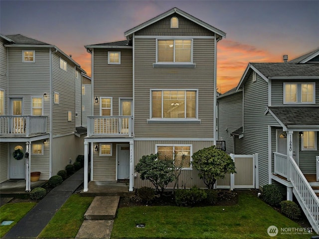 view of front of home with a balcony and a front lawn