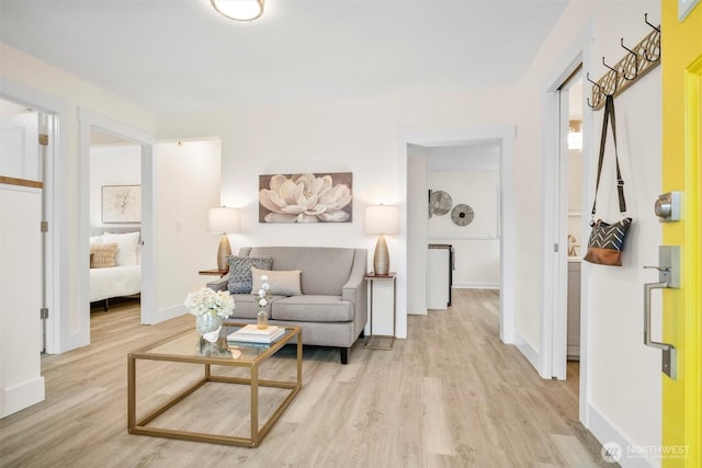 interior space featuring baseboards and light wood finished floors