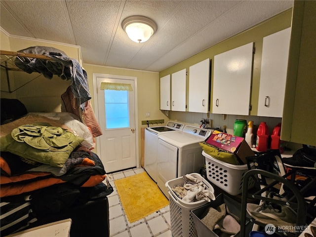 washroom with a textured ceiling, light floors, cabinet space, and washer and dryer