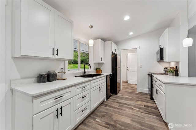 kitchen with black appliances, a sink, white cabinetry, and pendant lighting