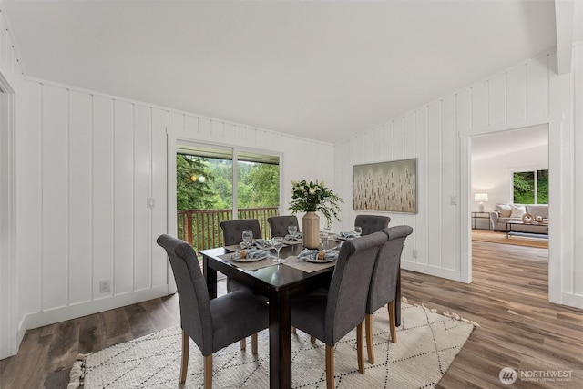 dining space with lofted ceiling, a wealth of natural light, and wood finished floors