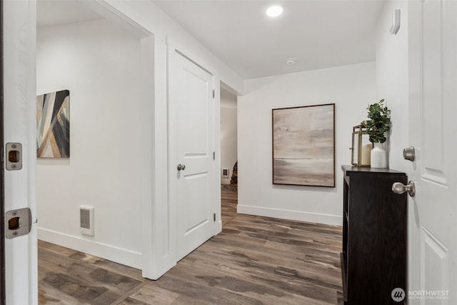 corridor with visible vents, dark wood finished floors, and baseboards