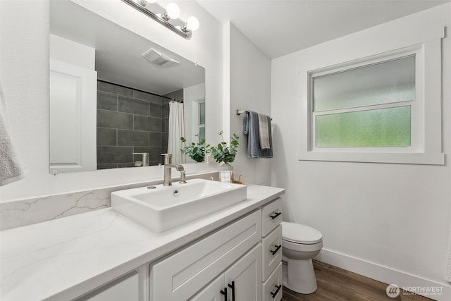 bathroom featuring visible vents, a shower with shower curtain, toilet, wood finished floors, and baseboards