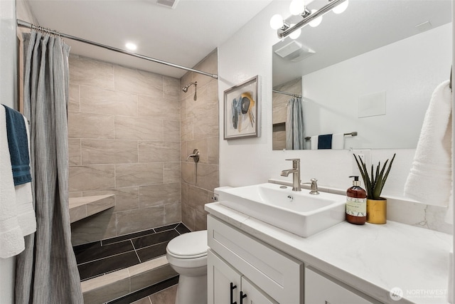 bathroom featuring a shower stall, vanity, and toilet