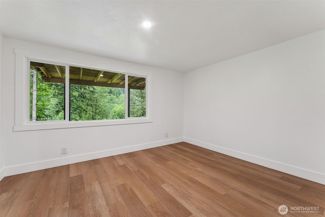 spare room featuring light wood-type flooring and baseboards