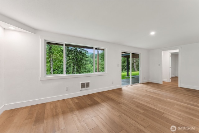 spare room featuring light wood-type flooring, visible vents, baseboards, and recessed lighting