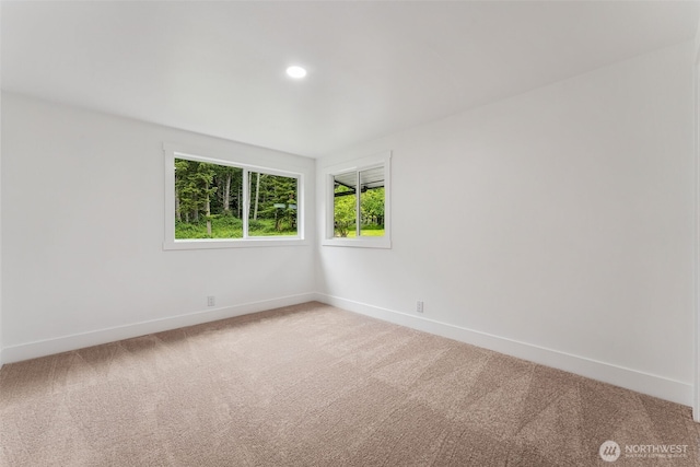 carpeted spare room featuring baseboards and recessed lighting