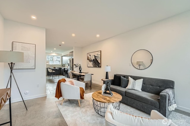 living room featuring concrete flooring, recessed lighting, and baseboards