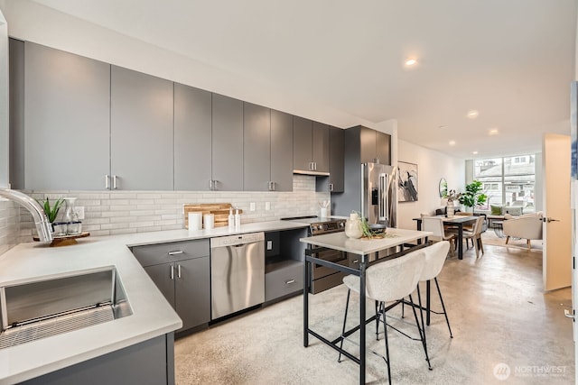 kitchen featuring a sink, stainless steel appliances, light countertops, and gray cabinetry