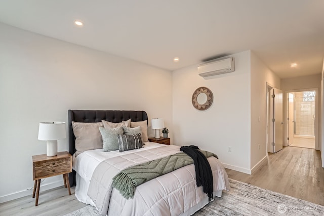 bedroom featuring recessed lighting, baseboards, a wall mounted air conditioner, and light wood finished floors