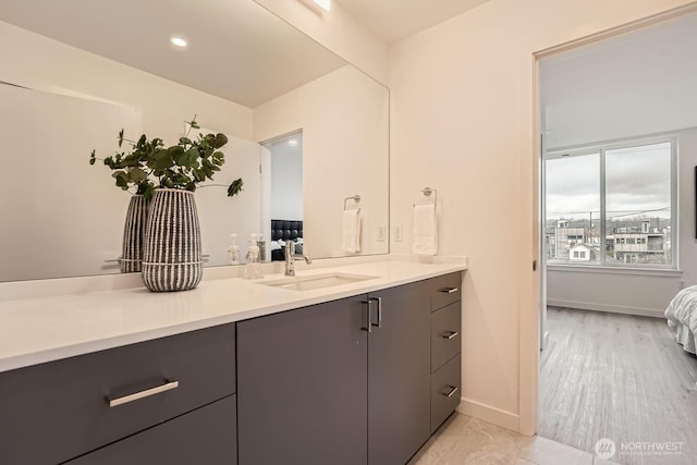 ensuite bathroom featuring vanity, baseboards, and ensuite bathroom