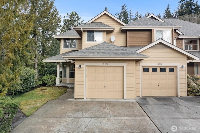 view of front facade with a shingled roof, driveway, and a garage