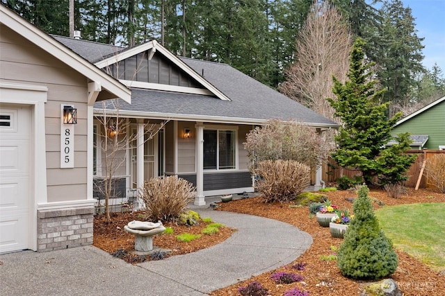 view of front of home with a shingled roof, an attached garage, and fence