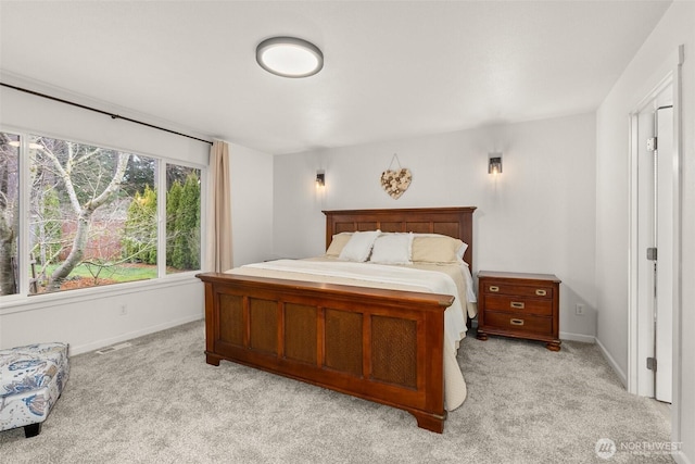 bedroom with baseboards, light carpet, and visible vents