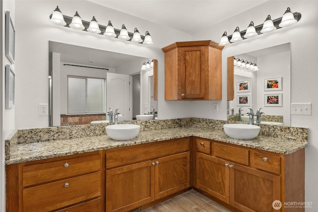 full bathroom featuring double vanity, wood finished floors, and a sink