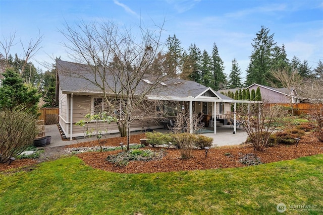 rear view of house with a patio, a lawn, and fence