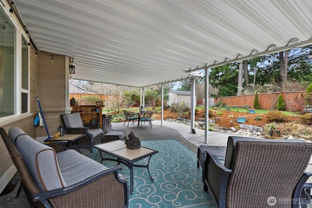 view of patio with an outdoor hangout area, an outbuilding, outdoor dining space, and fence