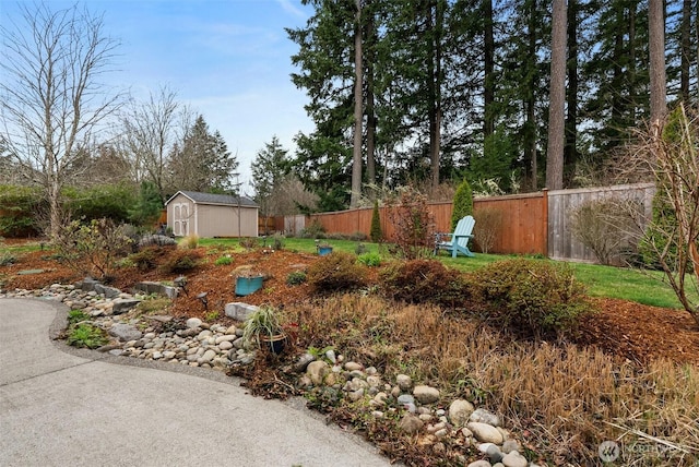 view of yard with a storage shed, fence, and an outbuilding