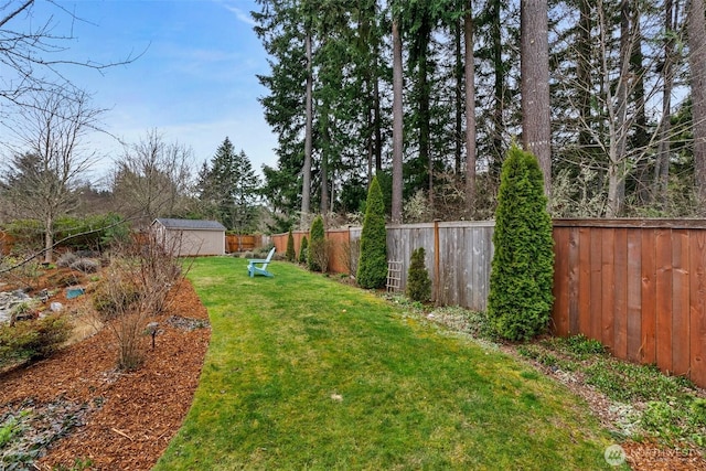 view of yard with an outdoor structure, a storage unit, and a fenced backyard