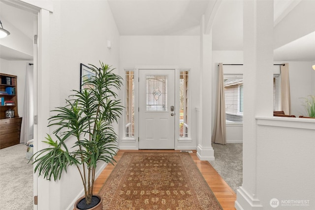 foyer entrance with wood finished floors and baseboards