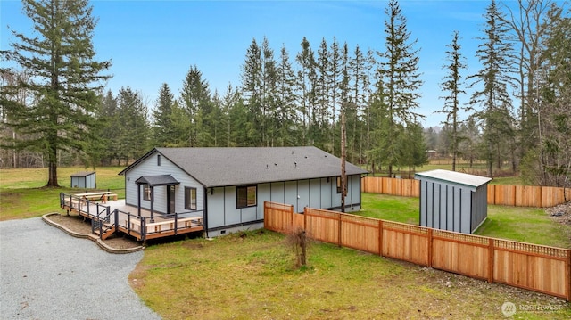 view of front of home with a storage shed, crawl space, a wooden deck, an outdoor structure, and board and batten siding