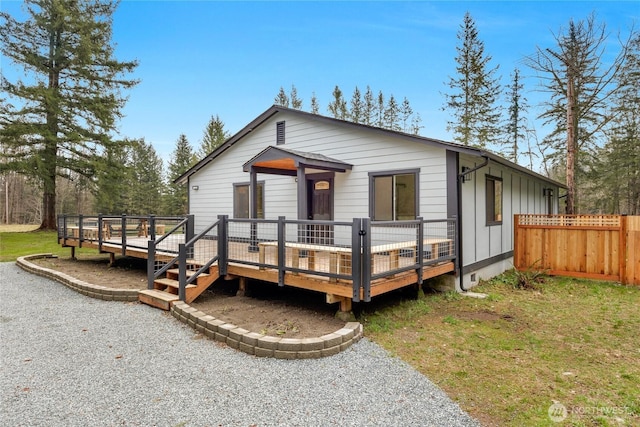 view of front of property with a front yard, a wooden deck, and fence