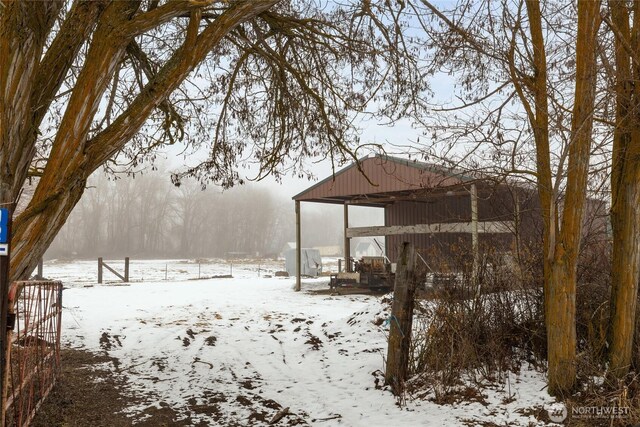 yard layered in snow with an outbuilding