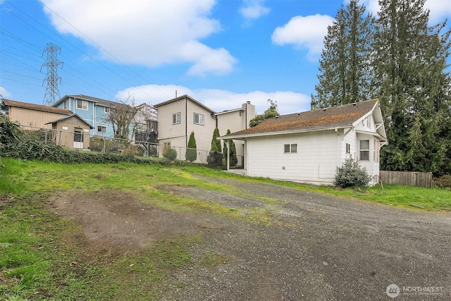 rear view of house with fence and a chimney