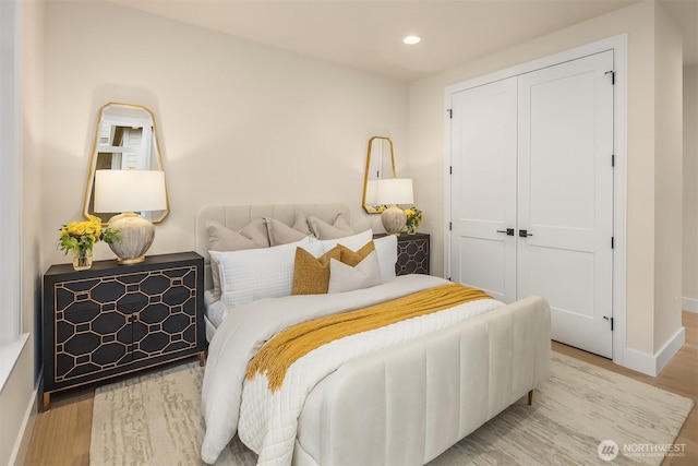 bedroom with recessed lighting, a closet, and wood finished floors